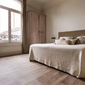 light browwn flooring with bed and large window